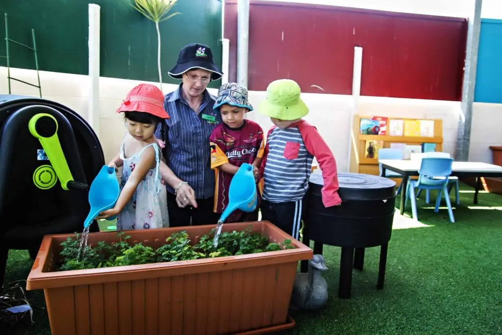 children in hats complete nature-based learning activity